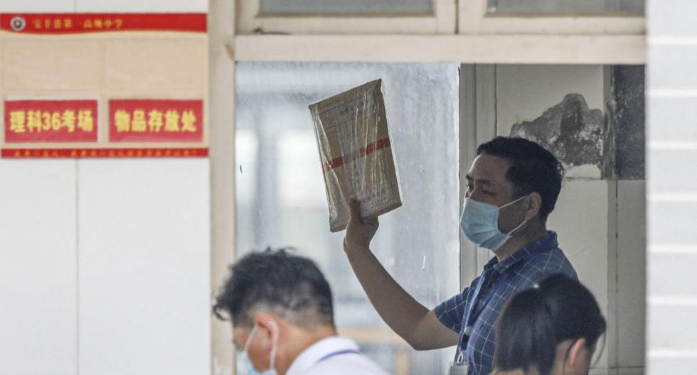Un maestro muestra los exámenes sellados a los estudiantes antes de un examen durante el primer día del Examen de ingreso a la universidad nacional (NCEE), conocido como "gaokao", en el condado de Baofeng, ciudad de Pingdingshan, en la provincia central china de Henan, el 7 de julio de 2020. (STR / AFP).