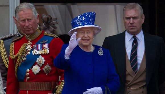 La reina Isabel II  saluda desde el balcón del Palacio de Buckingham flanqueada por sus hijos, el príncipe Carlos, el príncipe de Gales, y el príncipe Andrés, duque de York. (Foto: CARL COURT / AFP)