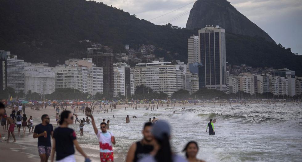 Los bañistas llegan a la playa de Copacabana en medio de la pandemia del coronavirus COVID-19 en Río de Janeiro, Brasil, el 29 de diciembre de 2020. (Foto de MAURO PIMENTEL / AFP).