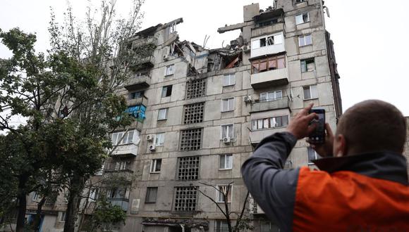 Un hombre toma una foto de su edificio residencial parcialmente destruido por un ataque con misiles en la ciudad de Toretsk, región de Donetsk, el 23 de septiembre de 2022. (Foto de Anatolii Stepanov / AFP)