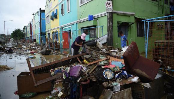 Un residente arroja escombros llenos de barro de sus casas, después de una inundación provocada por un fuerte aguacero debido a la tormenta tropical Yagi. (Foto referencial: AFP)