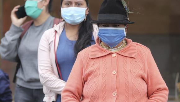Mujeres con máscaras para frenar la propagación del nuevo coronavirus esperan en una parada de autobús, en Cayambe, Ecuador. (AP/Dolores Ochoa).