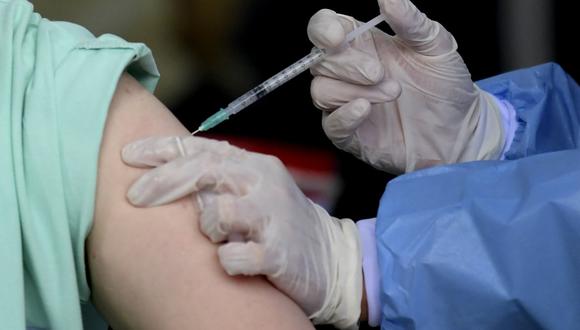 Dos mujeres “de unos 20 años vestidas como abuelas” trataron de vacunarse con la segunda dosis contra el COVID-19. (Foto: Raul ARBOLEDA / AFP)