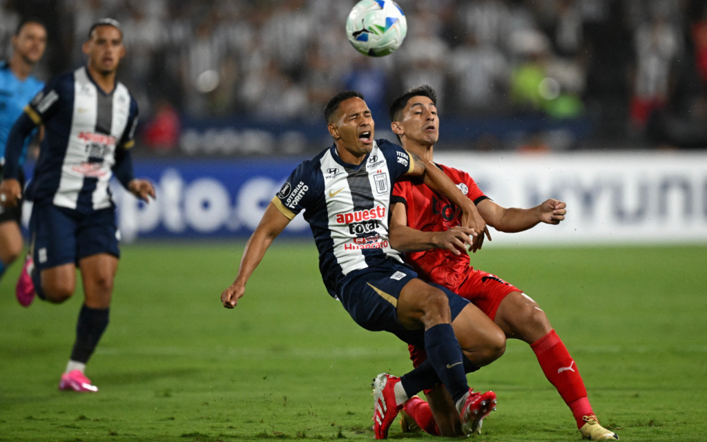 Renzo Garcés (Alianza) disputa una pelota con Gustavo Aguilar (Libertad).